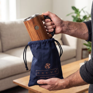 A man lifting the wooden CHUUG tankard from its navy canvas gift bag